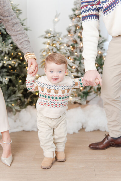 brothers wearing red tartan christmas pajamas in front of a christmas tree
