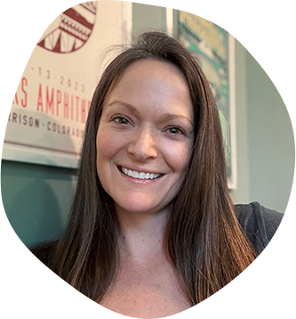 Mandi Gum, art director, designer and owner of Mandi Gum Design. She has brown hair and green eyes and is wearing a dark blue trucker hat.