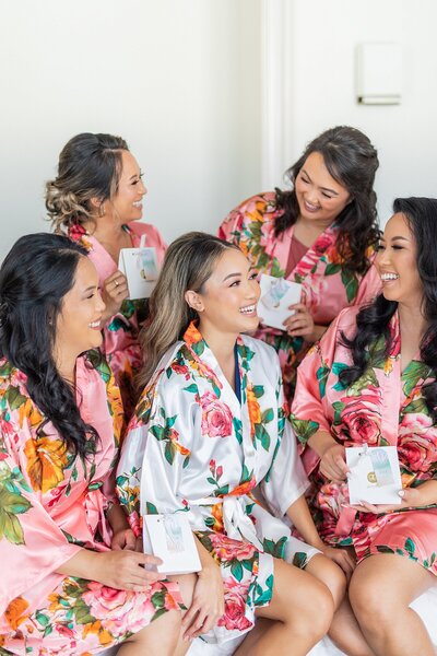 Bride and bridesmaids in their robes laughing together at the Ebell of Long Beach.