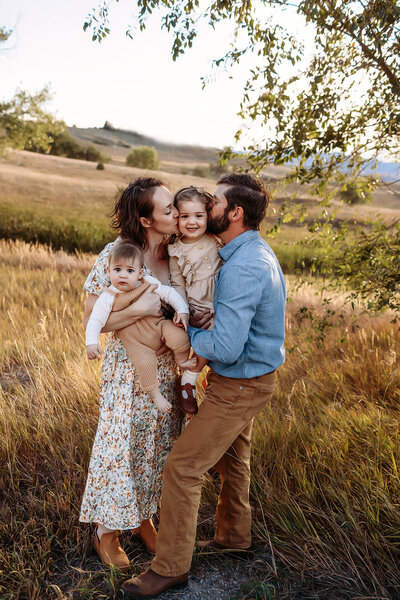 family playing in a field in broomfield, co during their photo session at sunset