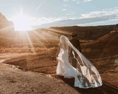 bride and groom walking into the sunset