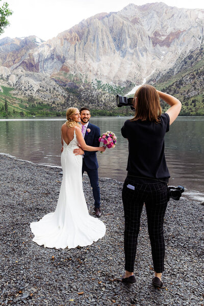 A photographer taking pictures of a newlywed couple