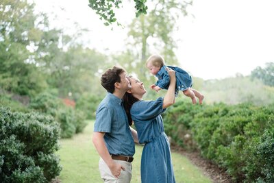 a-mom-and-dad-are-holding-their-one-year-old-at-cheekwood-for-her-1-year-old-portraits-at-cheekwood-with-dolly-delong-photography