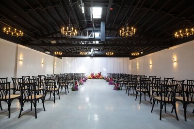 mock ceremony setup in large Locus space, natural light from original skylights and wrought iron romantic chandeliers spread throughout