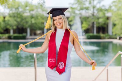 A University of South Carolina student taking her senior portraits on campus in front of the Thomas Cooper Library fountain