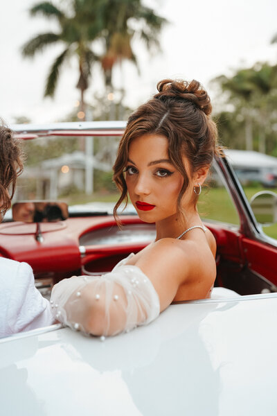 Bride looking over back of vintage car