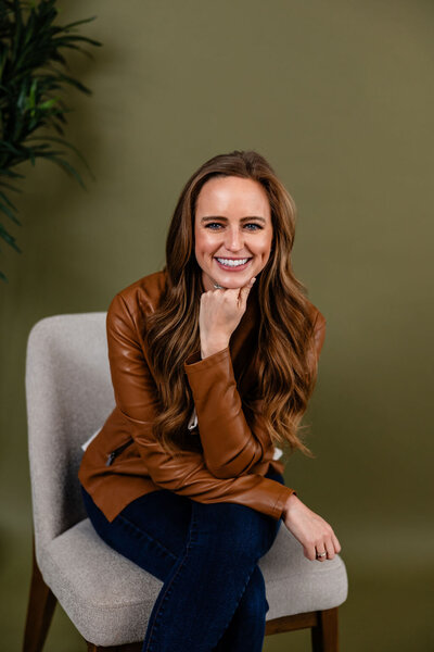 Headshot of JaCee Petko, Christian life coach, sitting in a chair in front of a green wall