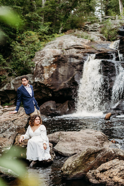 Couple takes engagement portraits in front of waterfall