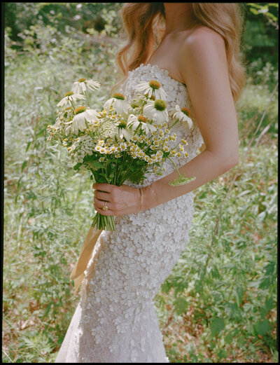 Wedding guests raising bride up on a chair during wedding reception