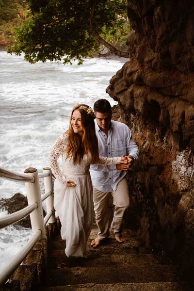 Couple walking up beach steps on the side of a cliff