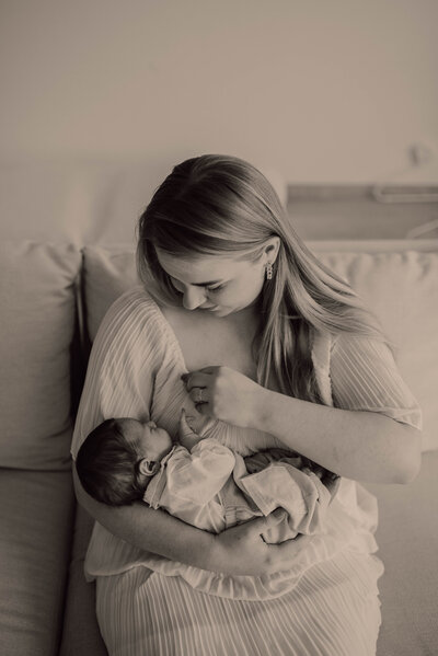Mama kijkt baby liefdevol aan tijdens newbornshoot