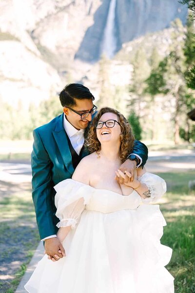 Bride and groom smiling in front of yosemite valley on their wedding day captured by GunnShot Photography