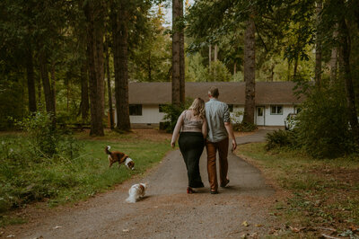 Couple walking through Forest with theirs dogs back to the cabin