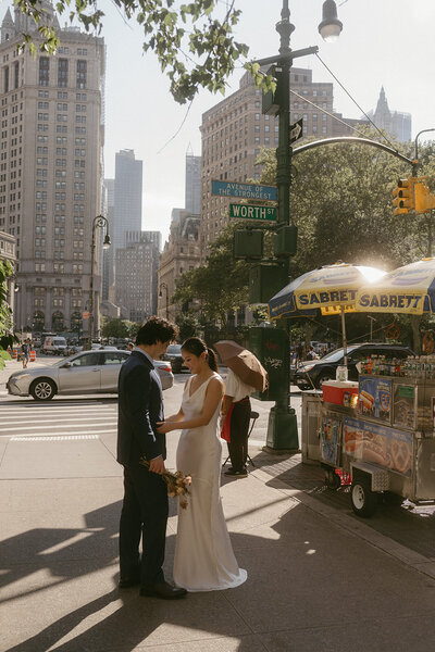 bride and groom in front of hot dog stand during NYC elopements shot by Elsie Goodman Photography | NYC Elopement Packages