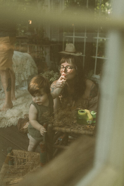 A mom kisses on her baby boys fingers in Das Hinterhaus of Marietta, GA. 