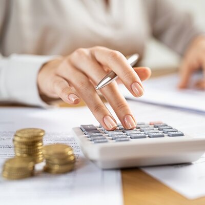 Stock photo of a person typing on a calculator to represent traditional home value calculators