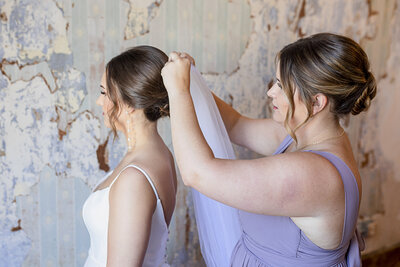 Girl Fixes Wedding Veil On Bride In Flint Hills Wedding Venue