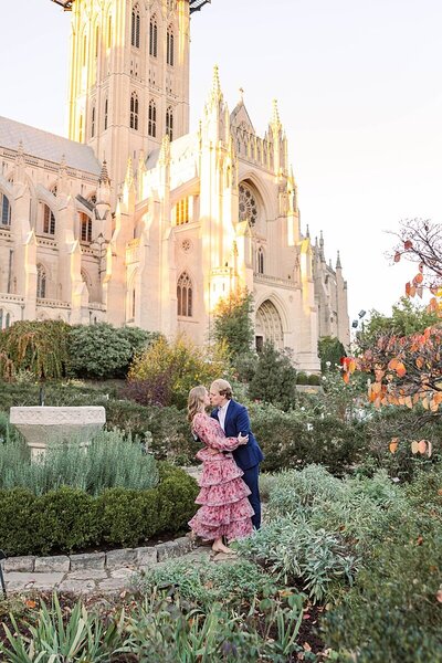 Washington DC engagement session at the National Cathedral with couple posing by gothic arches and landscaped grounds during golden hour
