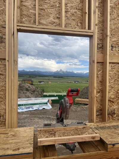 a general contractor's chop saw in a window with teton views