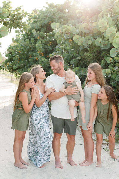 Family smiling on the beach at sunset captured by photographer in Central Fl