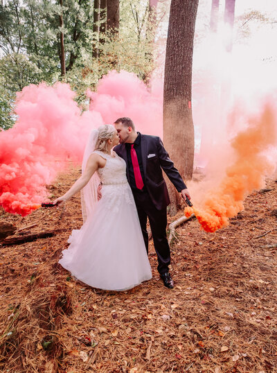 Couple in woods with smoke bombs