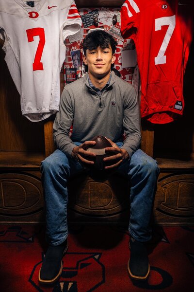 Senior Athlete with Football in Locker Room