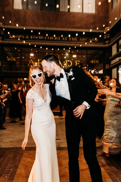 Couple does sparkler exit at the Hyatt Regency Arcade at black tie wedding.