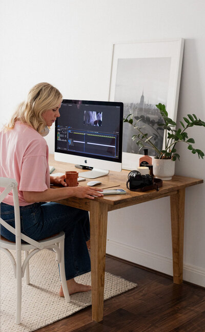 Behind the scenes of Jessie for The Film Room editing a wedding video at her desk in her home office.