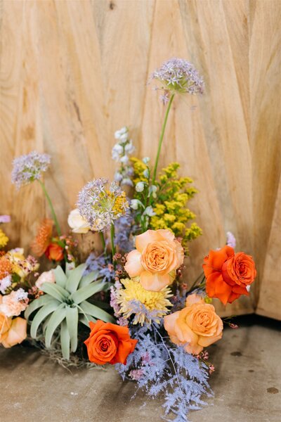 Unique wedding floral arrangement featuring peach and orange roses with desert-inspired textures, perfect for bold Central Texas weddings.