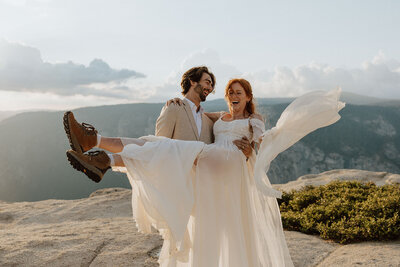 groom holding bride, bride and groom are laughing