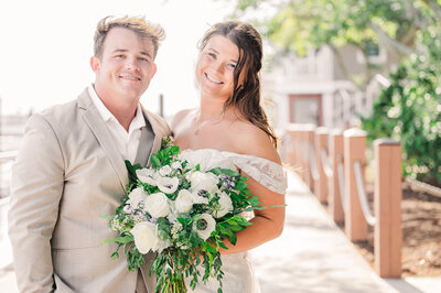 A bride and groom on the oceanside boardwalk in Southport North Carolina by JoLynn Photography, a destination wedding photographer