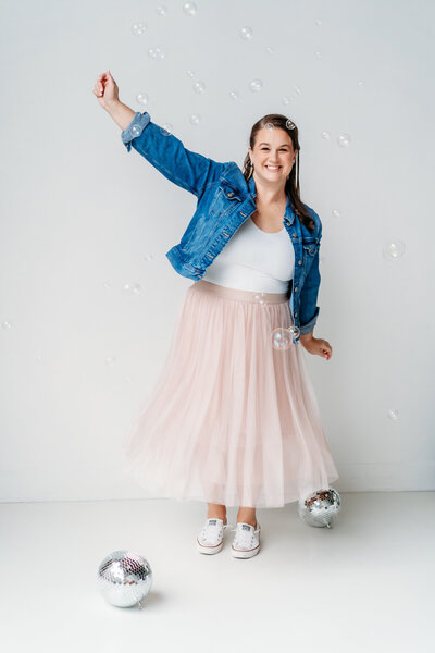 Woman dancing with disco balls on the floor.