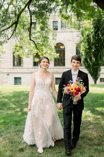 Couple holding hands and walking together on wedding day