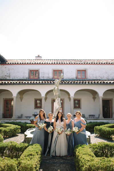 bride and her bridesmaids in various shades of blue at villa terrace in milwaukee wisconsin