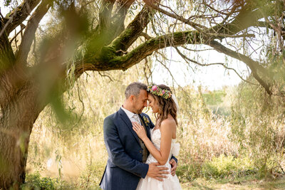 Bride and groom posing for portrait with white walls