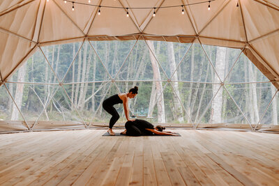 Two girls practicing yoga on a retreat on Bowen Island with Wildly Well Retreats