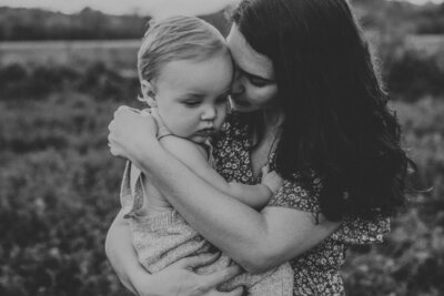 Black and white photo of mother holding child close