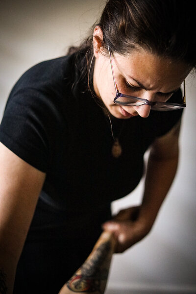 A woman massage therapist working on a client