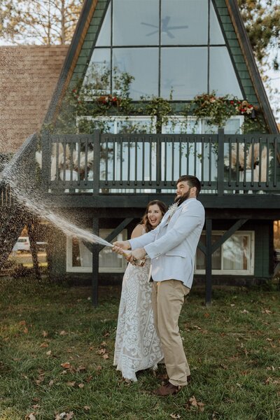 bride and groom popping champagne
