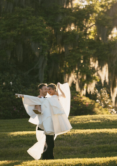 bride and groom standing next to purple flowers