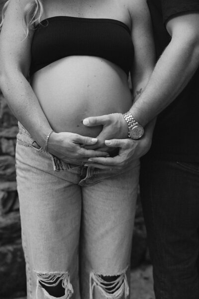 close up of mom and dad holding hands over baby bump during a maternity session with RVA maternity photographer