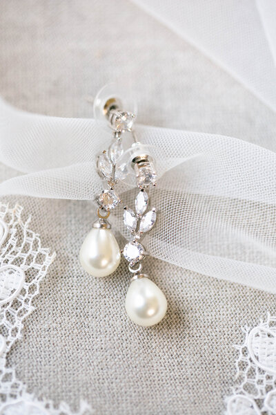 Wedding earrings with diamonds and pearls on veil