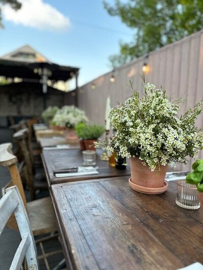 Bride and Groom exchanging vows under outdoor wedding pergola at Eden Barn Cumbria Lake District with flower arch flower installation apricot flowers pampas eucalyptus