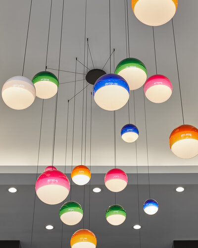 A cluster of tritone globe pendant lights hanging from the ceiling