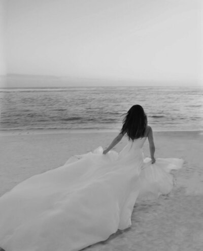 Bride joyously running on the beach, capturing the freedom and bespoke elegance of LIMCO’s wedding dance experiences.