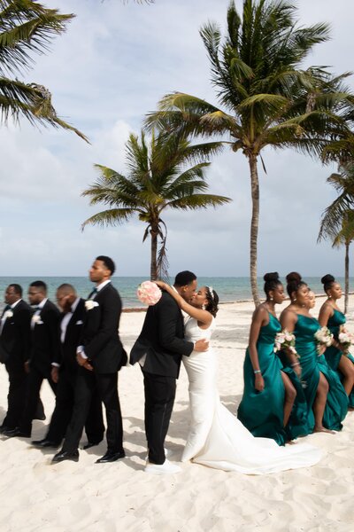 A group of bridesmaids and groomsmen on the beach.