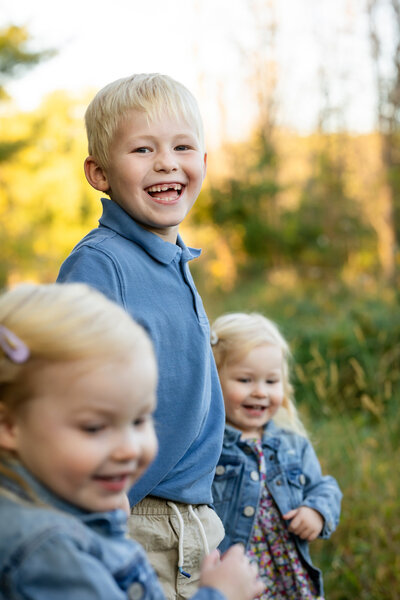 Fall family throwing leaves in air for Twin Cities Family Photographer