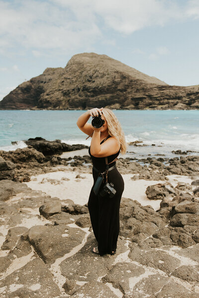 Maui Elopement Photographer captures woman holding camera while a couple elopes in Maui