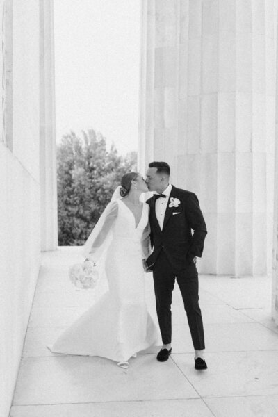 bride and groom hold hands while leaving wedding venue