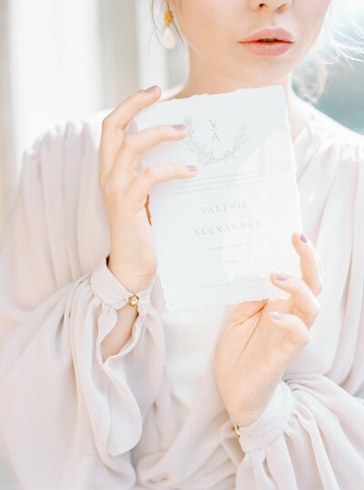 Bride getting ready before the wedding, holding her wedding invitation